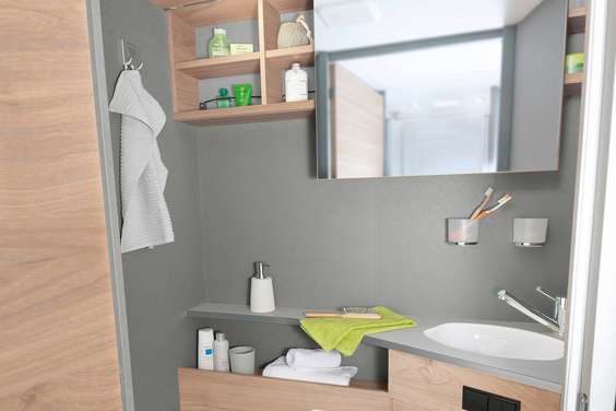 Lyst og moderne toalettrom med praktisk speil som kan skyves sideveis, samt mange hyller og lagringsmuligheter
